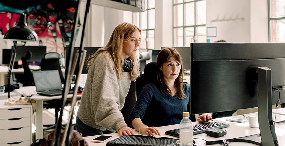 Two women looking at a screen in an office